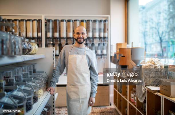 smiling owner standing by rack at zero waste store - green belt fashion item stock pictures, royalty-free photos & images