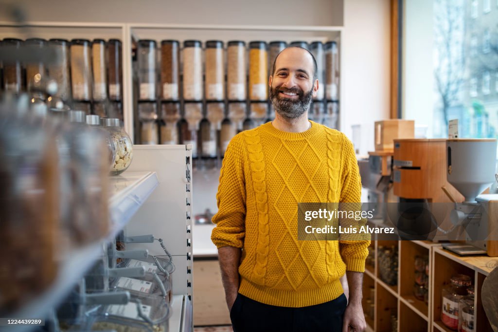 Smiling customer standing by rack at zero waste store