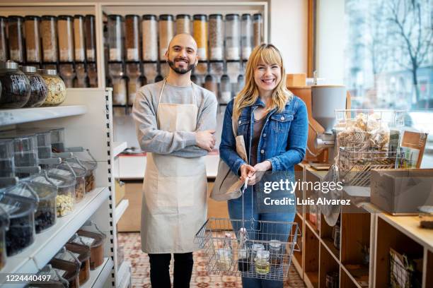 young customer standing by owner at zero waste store - green belt fashion item stock pictures, royalty-free photos & images