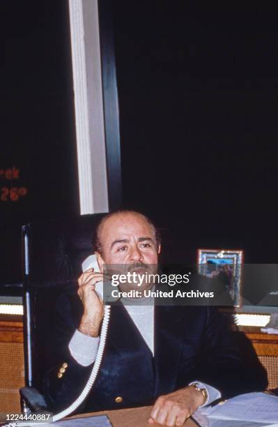 Businessman Adnan Khashoggi at his desk in his office at Olympic Tower in New York, USA 1986.