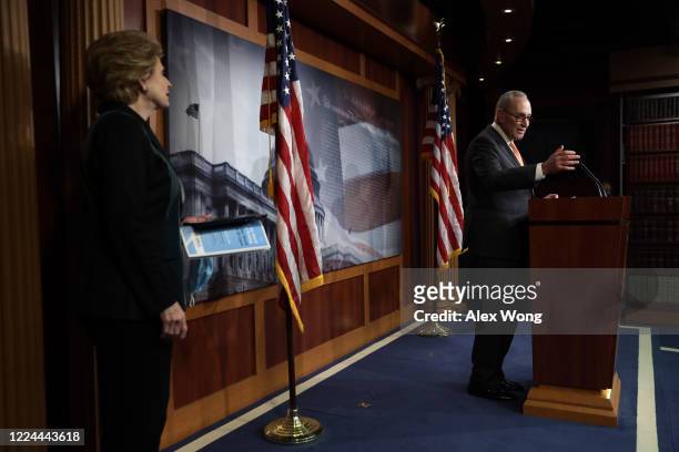 Senate Minority Leader Sen. Chuck Schumer speaks to members of the press as Sen. Debbie Stabenow listens during a news briefing at the U.S. Capitol...