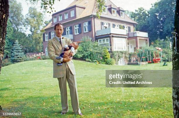 Historian Friedrich Wilhelm Prince of Prussia with his baby son Joachim Albrecht in the garden at Bremen, Germany, 1984.