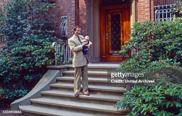 Historian Friedrich Wilhelm Prince of Prussia with his baby son Joachim Albrecht at the entrance stairs of his home at Bremen, Germany, 1984.