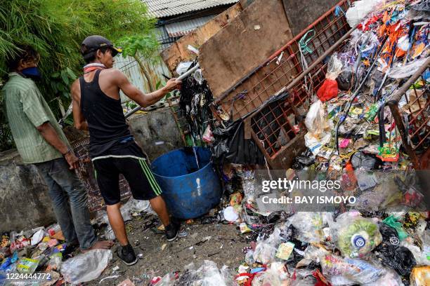 Workers collect trash including plastic waste from a neighbourhood dump site in Jakarta on July 3 after the local government implemented a ban...
