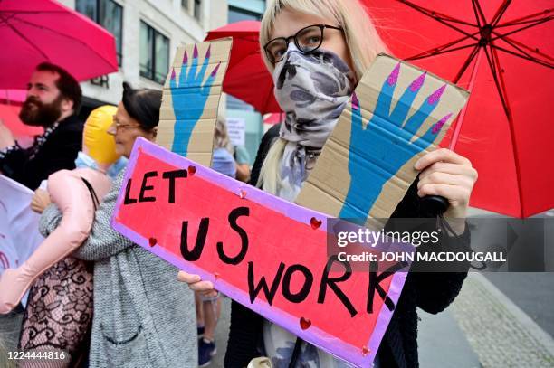 Sex workers hold placards during a protest to demand the reopening of brothels amid the new coronavirus pandemic on July 3, 2020 near the Bundesrat...