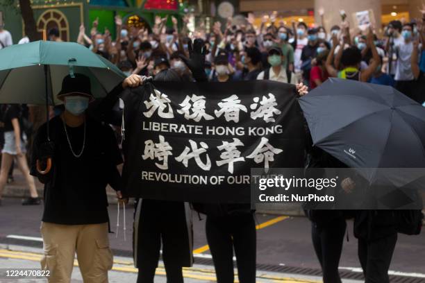 Pro-democracy protesters march on a street as they take part in a demonstration on July 1, in Hong Kong, China.