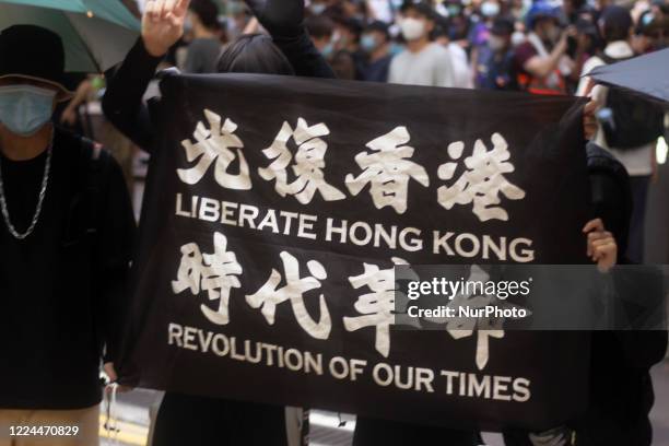 Pro-democracy protesters march on a street as they take part in a demonstration on July 1, in Hong Kong, China.