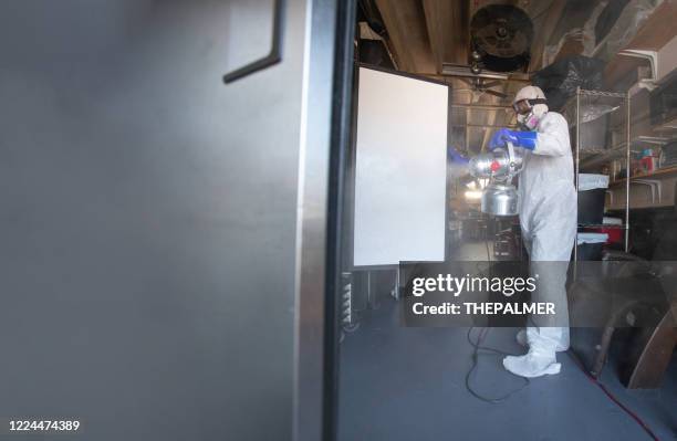 worker spraying a disifecting solution on a refrigerator - restaurant kitchen fridge stock pictures, royalty-free photos & images