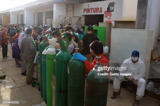 People make long queues to refill oxygen tanks for their relatives who are under treatment against COVID on May 09, 2020 in Iquitos, Peru. Iquitos,...