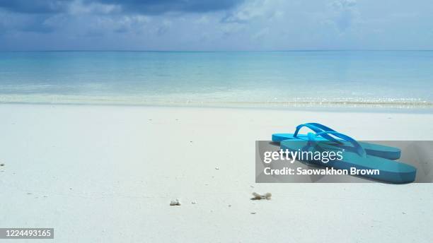 a pair of blue flip-flops left at a tropical beach in the maldives - beach tropical deserted blue sky stock-fotos und bilder