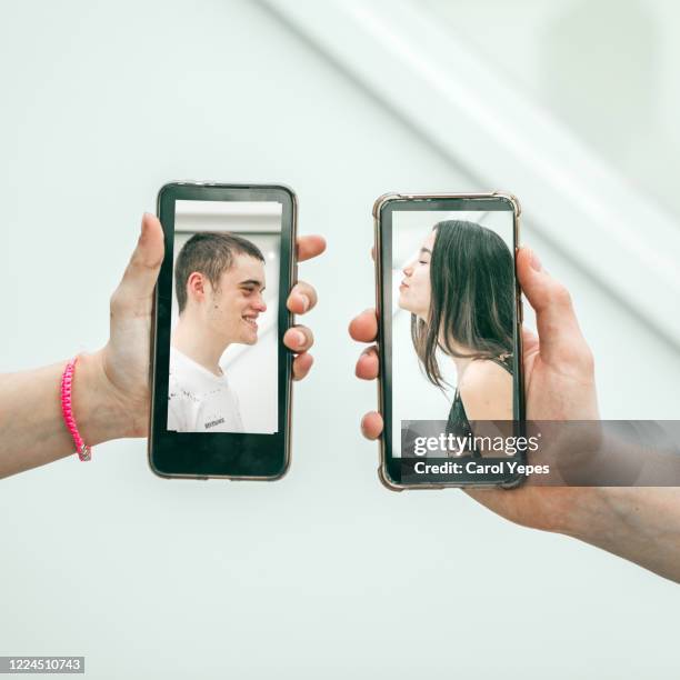 millennial couple kissing via mobile devices - human body part videos stock pictures, royalty-free photos & images