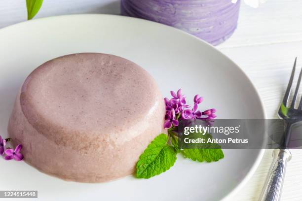 panna cotta decorated with lilac flowers and mint leaves - panna cotta stock pictures, royalty-free photos & images