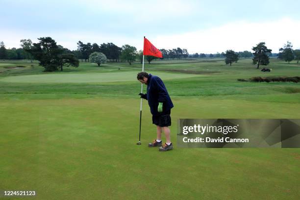 The flagstick is placed in the hole on the first green of The New Course by a member of the green-staff team as golf resumes in England under...