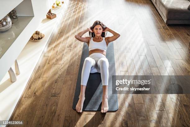 boven mening van atletische vrouw die sit-ups op oefeningsmat uitoefent. - sit ups stockfoto's en -beelden