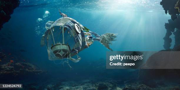 trash in sea in shape of open mouthed monster fish - sea cup stock pictures, royalty-free photos & images