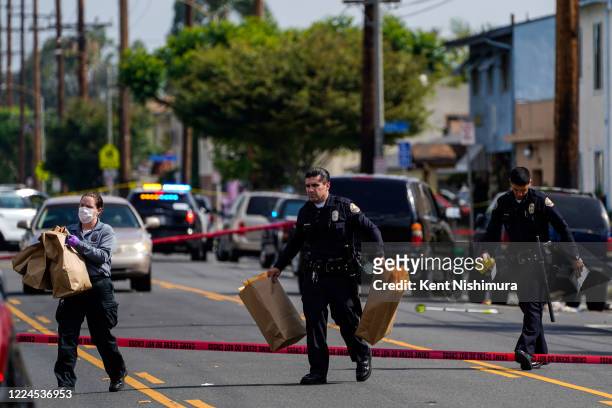Law enforcement officers at scene of a shooting at the 5800 block of Orange Avenue on Tuesday, June 30, 2020 in Long Beach, CA. One woman was killed...