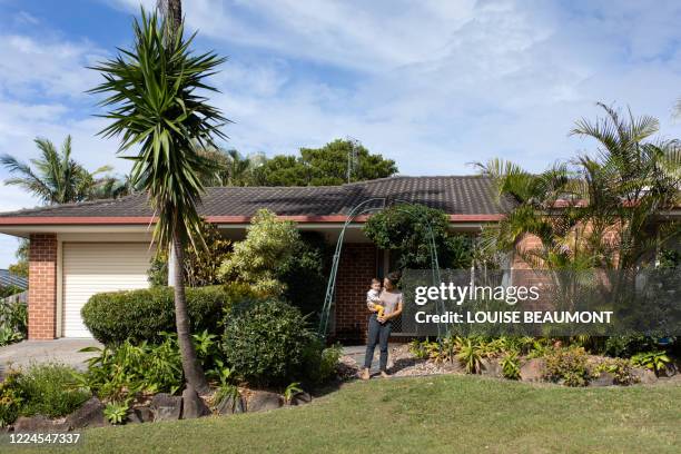 mum and daughter outside their house - family front door stock-fotos und bilder