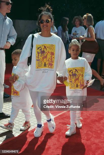 American actress and dancer Debbie Allen holds the hands of two of her children, Norman Nixon Jr and Vivian Nixon, with all three wearing matching...