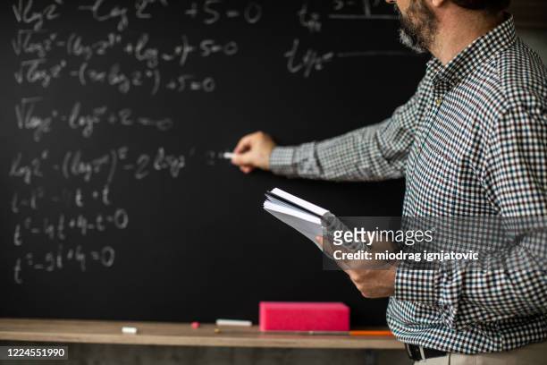 math professor writing mathematical formula on blackboard during online class - mathematician stock pictures, royalty-free photos & images