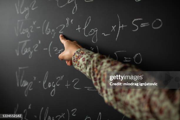 math teacher showing solution for math problem on blackboard - math tutor stock pictures, royalty-free photos & images