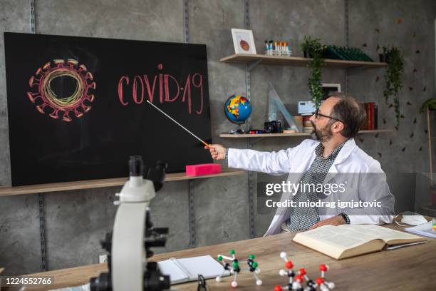 doctor teaching students online about covid-19 prevention during isolation period - pointer stick stock pictures, royalty-free photos & images