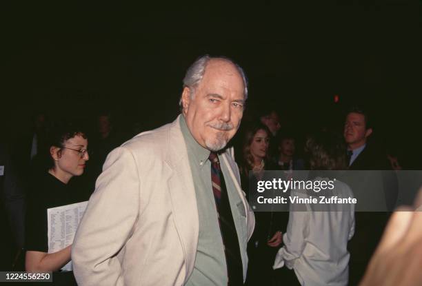 American film director Robert Altman wearing a beige jacket over a pale green shirt with a striped tie at an event, circa 1995.