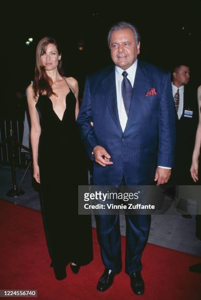 American fashion model and actress Carol Alt, wearing a black dress with a plunging neckline, and American actor Paul Sorvino, in a dark blue suit,...