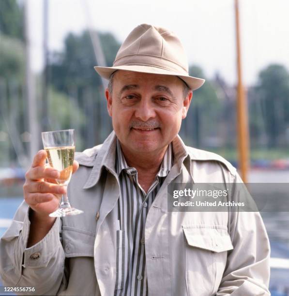 Portrait photo of the US-American actor John Hillerman with a sparkling wine, Germany, circa 1990s.