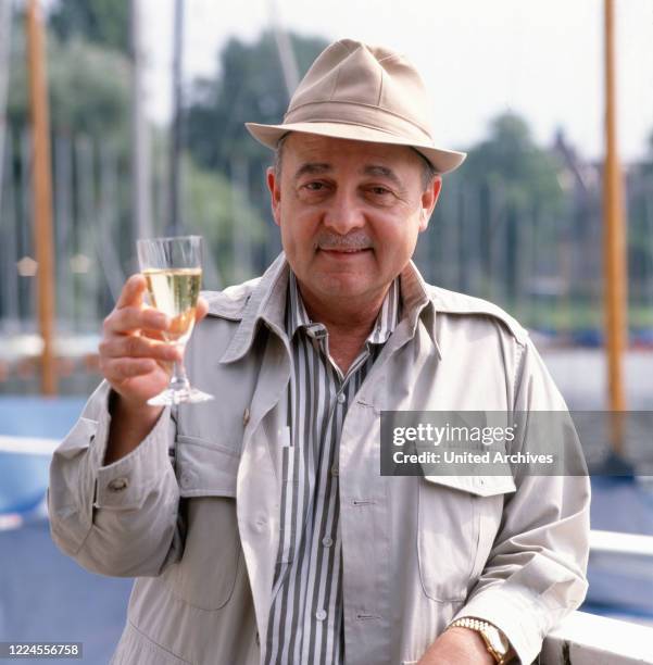 Portrait photo of the US-American actor John Hillerman with a sparkling wine, Germany, circa 1990s.