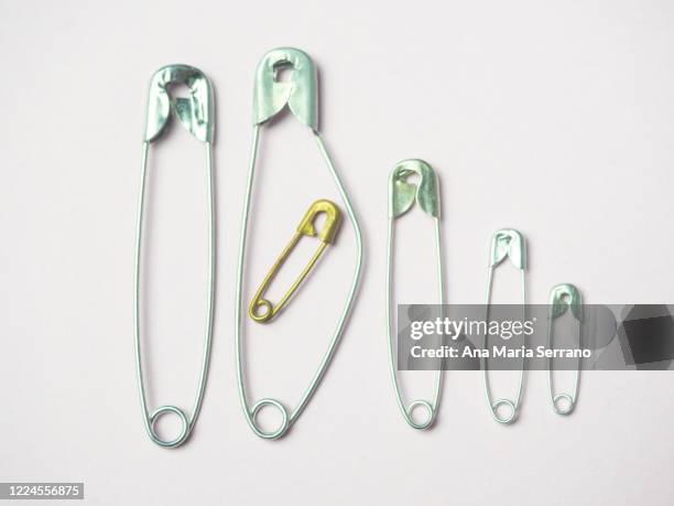 sewing safety pins representing a family with three children and a pregnant woman. large family concept - darstellen stock-fotos und bilder