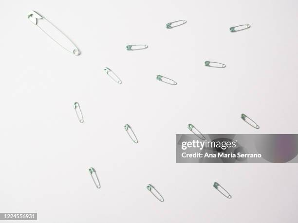 sewing safety pins following one of them. leadership concept - servant leadership stock pictures, royalty-free photos & images