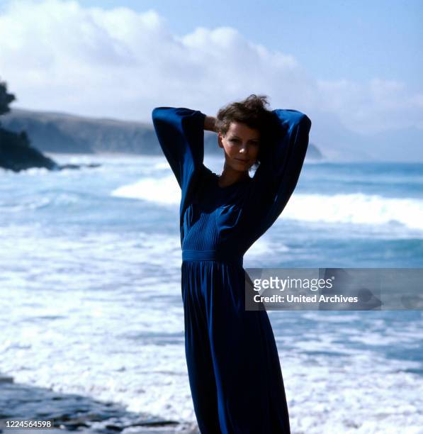 German singer Su Kramer posing on the beach in a blue dress, mid 1970s.