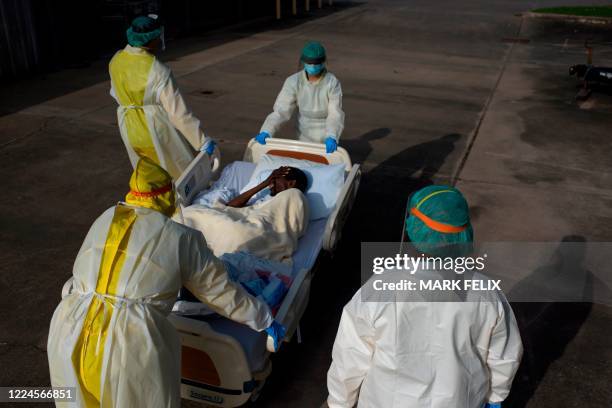 Healthcare workers push a patient into a less intensive unit from the Covid-19 Unit at United Memorial Medical Center in Houston, Texas on July 2,...