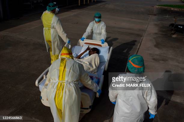 Healthcare workers push a patient into a less intensive unit from the Covid-19 Unit at United Memorial Medical Center in Houston, Texas on July 2,...