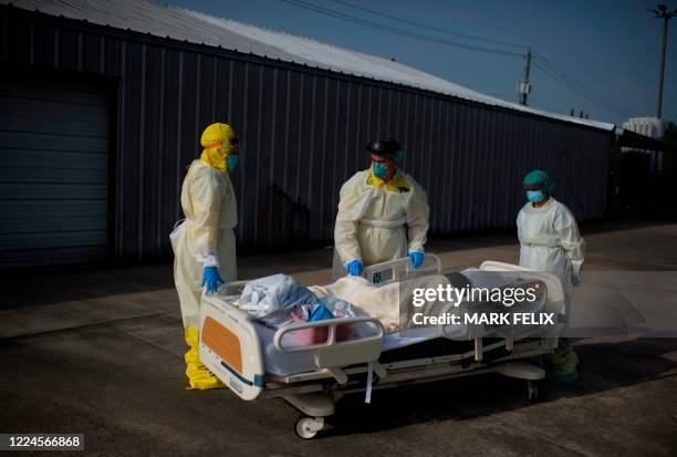 Healthcare workers push a patient into a less intensive unit from the Covid-19 Unit at United Memorial Medical Center in Houston, Texas on July 2,...