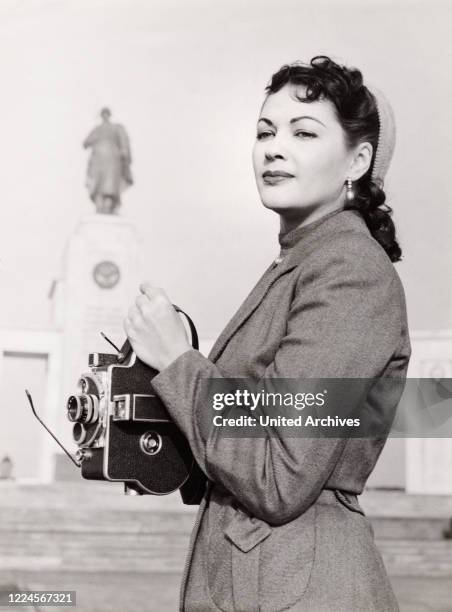 American actress Yvonne de Carlo with a film camera at Berlin, Germany, 1957. .