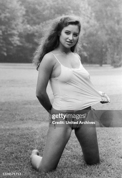 German singer, musical actress and TV host Isabel Varell posing for a photo shooting at a public garden, Germany circa 1984.