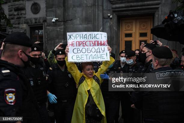 Russian police officers detain an activist holding a sign reading "Journalist is not a criminal, Freedom for Svetlana" during a demonstration in...