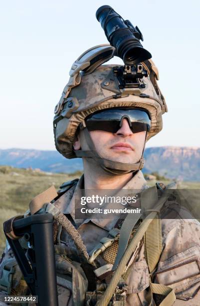 equipped soldier in camouflaged uniform with rifle - capacete militar imagens e fotografias de stock