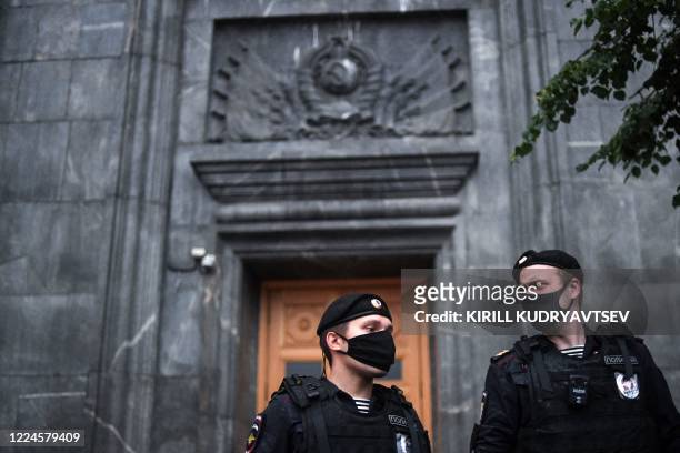 Russian police officers stand guard during a demonstration in support of journalist Svetlana Prokopyeva in front of the headquarters of the FSB...