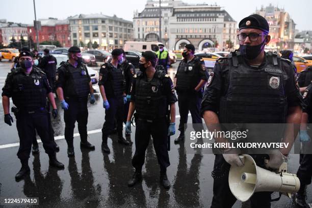 Russian police officers stand guard during a demonstration in support of journalist Svetlana Prokopyeva in front of the headquarters of the FSB...