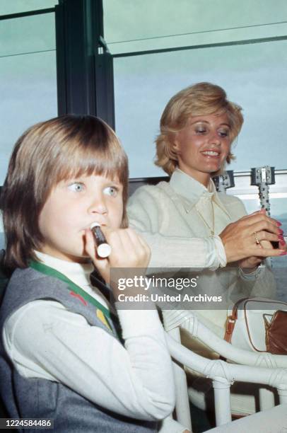 Charles Bronson's wife Jill Ireland with daughter Zuleika Bronson at a restaurant, France, 1970s.