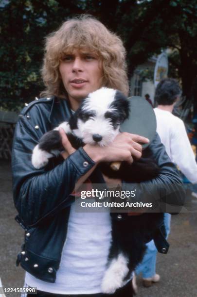 German actor, singer and TV presenter Benny Schnier with his bobtail puppy Wuschel, Germany, 1980s.