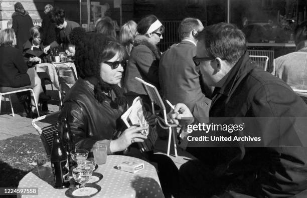 Austrian bassist, singer and producer Andy Fisher dining at a restaurant, Germany, 1960s.