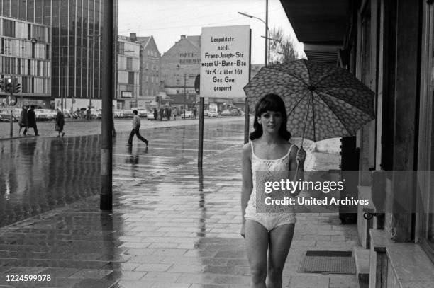 German photo model Pascher presenting lingerie at Herzogstrasse street in Munich, Germany, 1960s.