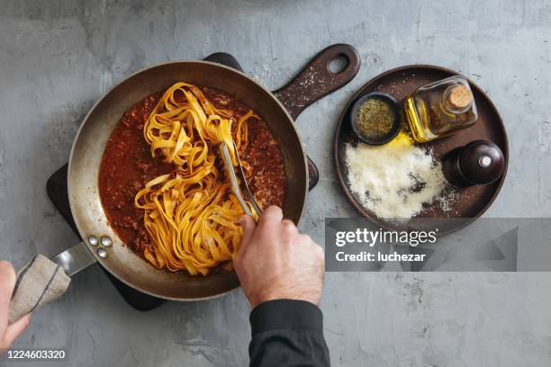 man cooking classic tagliatelle with sauce bolognese - molho bolonhesa imagens e fotografias de stock