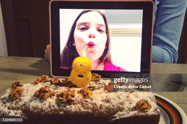 celebrating creative birthday of child using video call with digital tablet during covid-19 quarantine blowing candle. - zoom birthday stock pictures, royalty-free photos & images