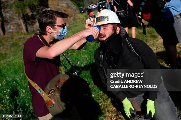 Man washes the eyes of another one after he was pepper sprayed by police as activists and members of different tribes from the region block the road...