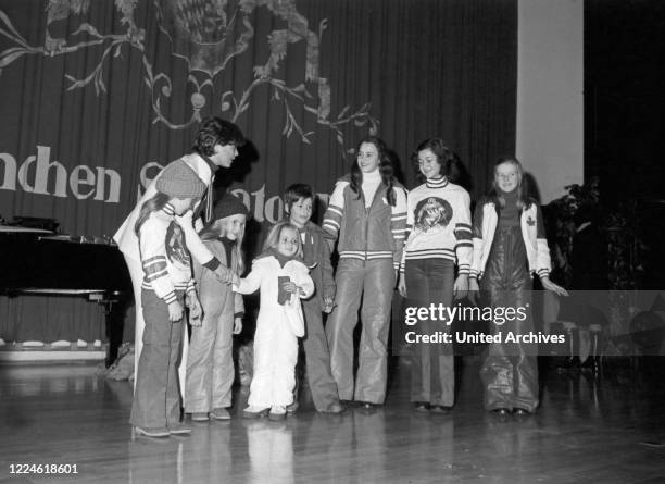 Children on stage with actress Uschi Glas at the Munich Sheraton Hotel, Germany, 1970s.