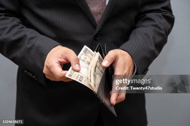 business person gripping 10000 japanese yen banknote from wallet, earning and invesetment concept - japanese yen note stockfoto's en -beelden